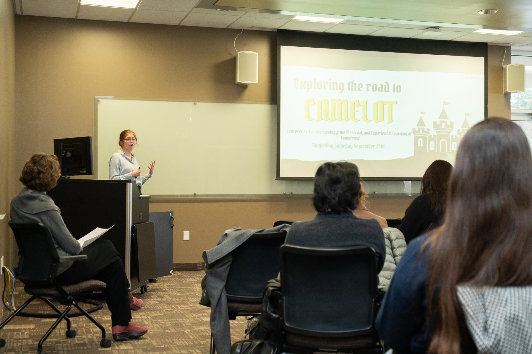Amelia Mara Dreyer presenting at podium to a group