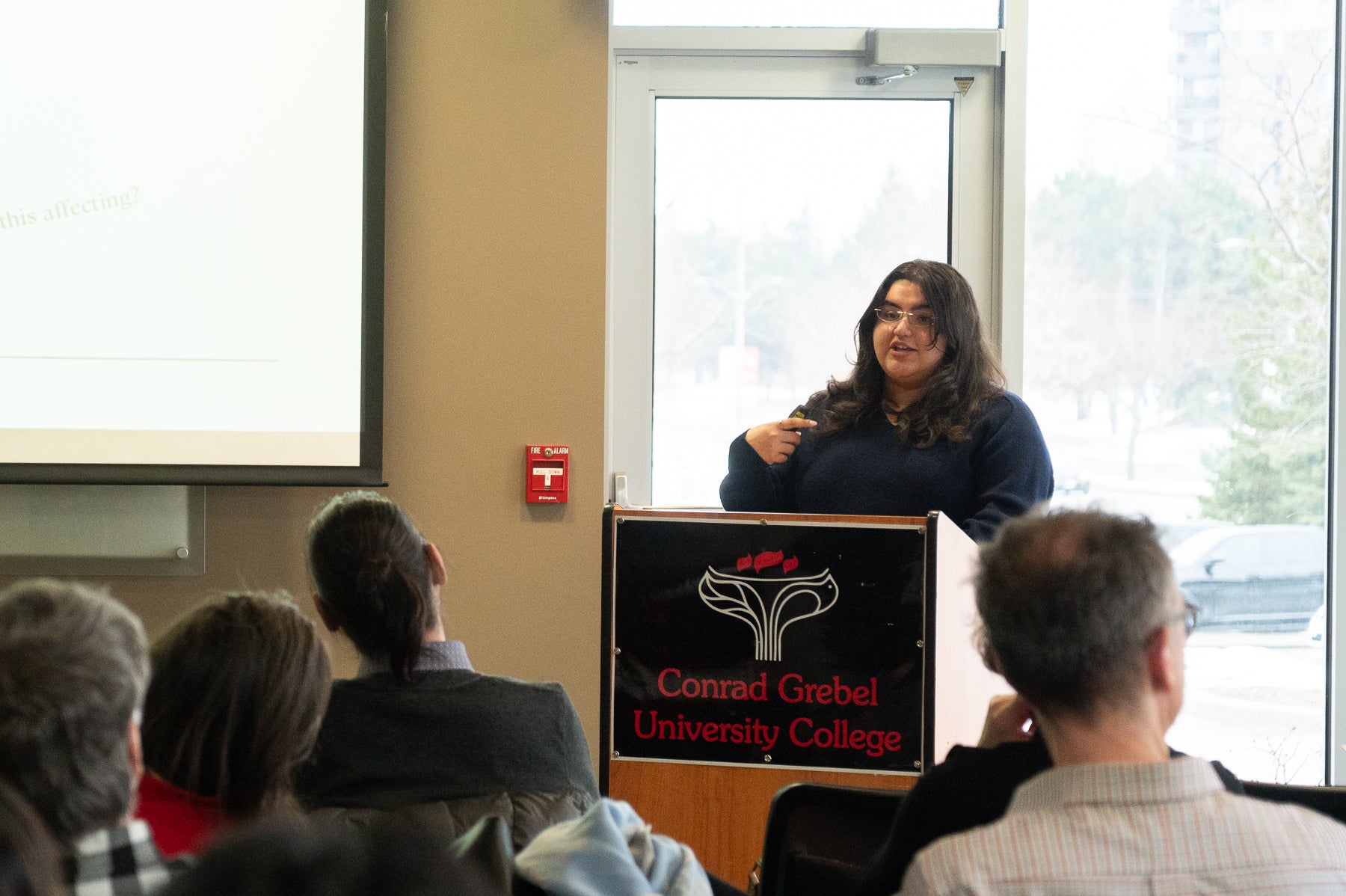 Serin Enver standing at podium looking onto a crowd