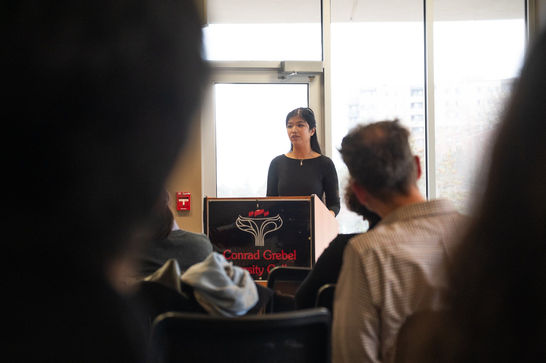 Yvonne Ly standing at podium facing crowd of people