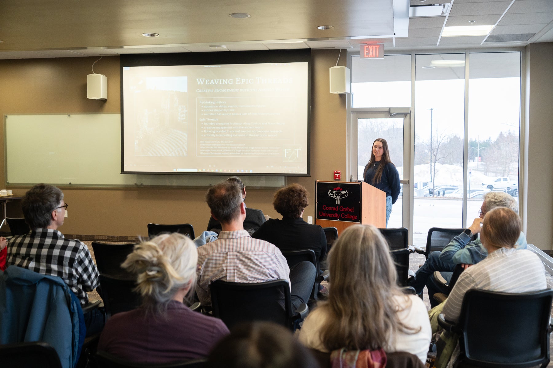Madelynne Parish presenting at a podium to a group of people 