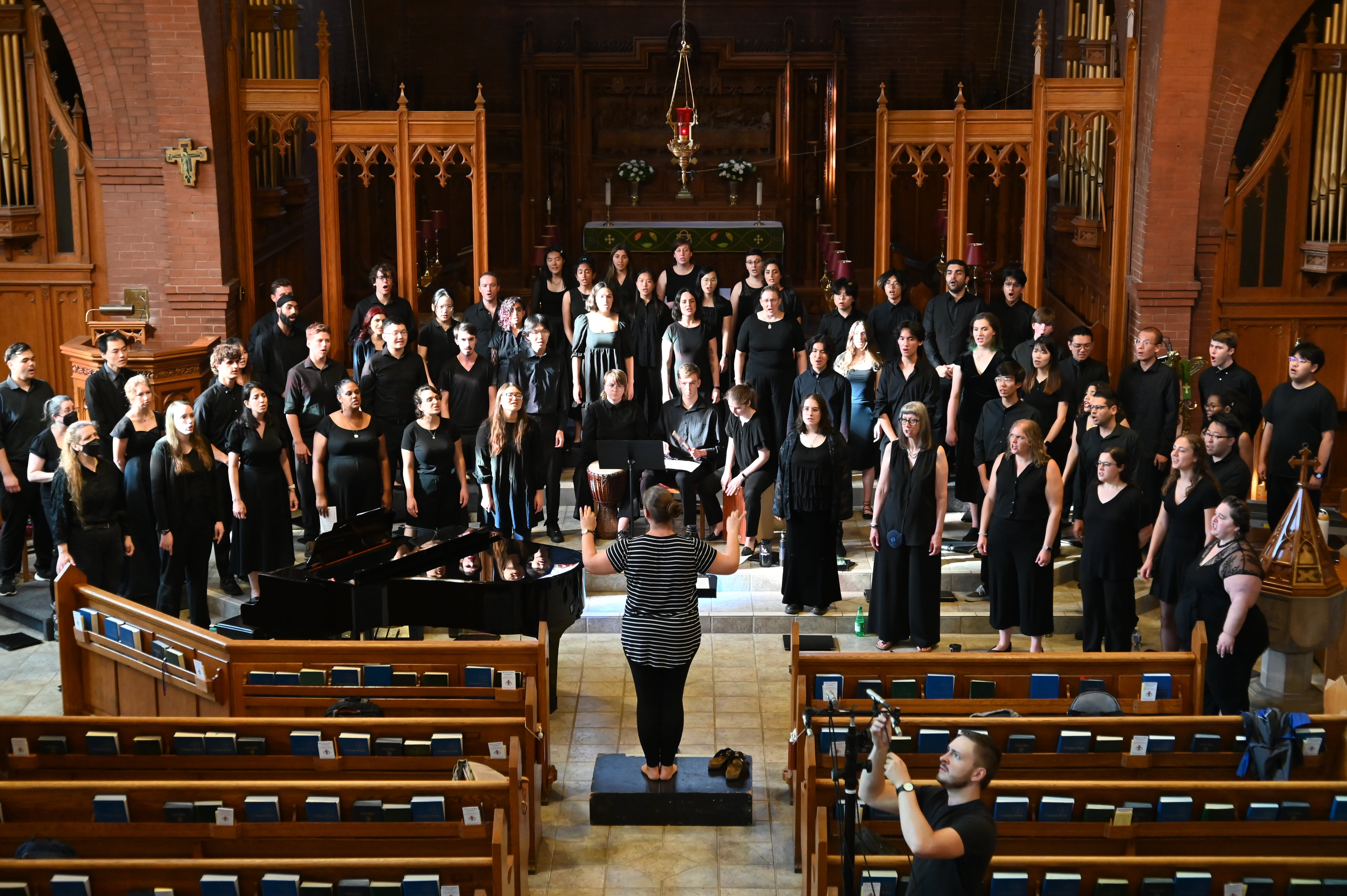 Conductor with choir in church sanctuary