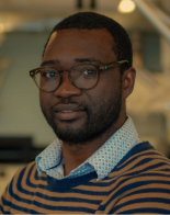 a man with glasses smiling
