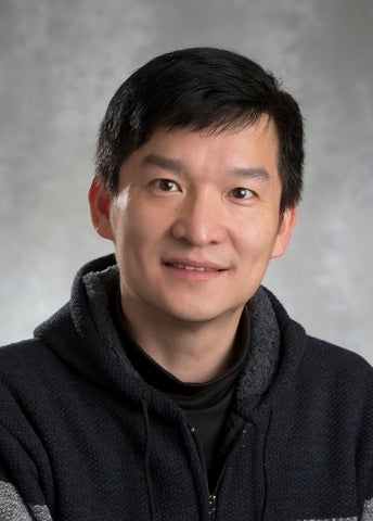 a man with black hair smiling