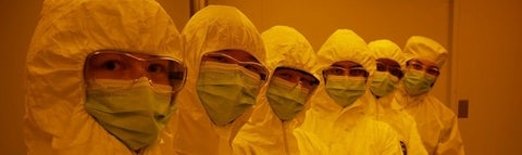Six lab technicians in clean room suits 
