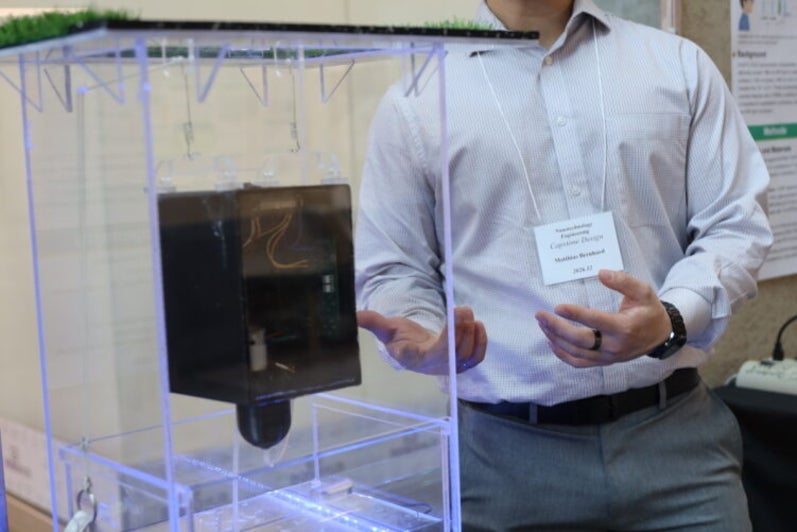 a man gesturing to a black object in a box