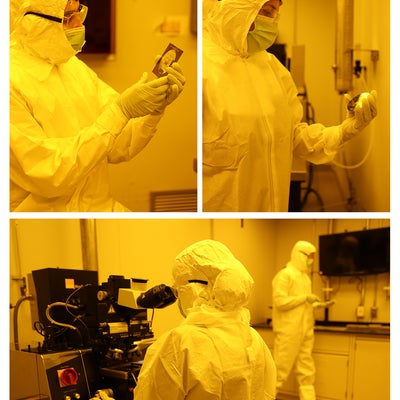 Technicians working in the cleanroom with protective gear on.