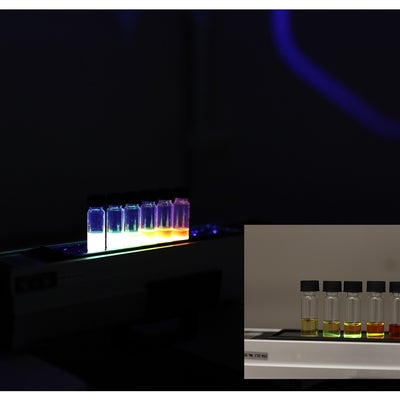 Samples fluorescing different colors in the dark and under natural light.