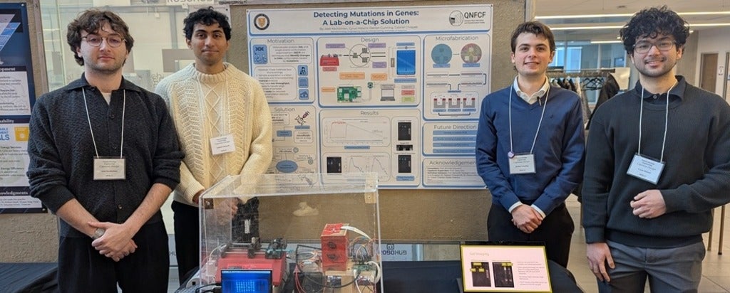 Four men standing on either side of a poster board