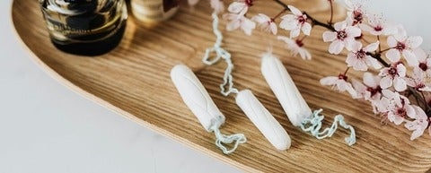 a wooden board with purple and white flowers and three white tampons