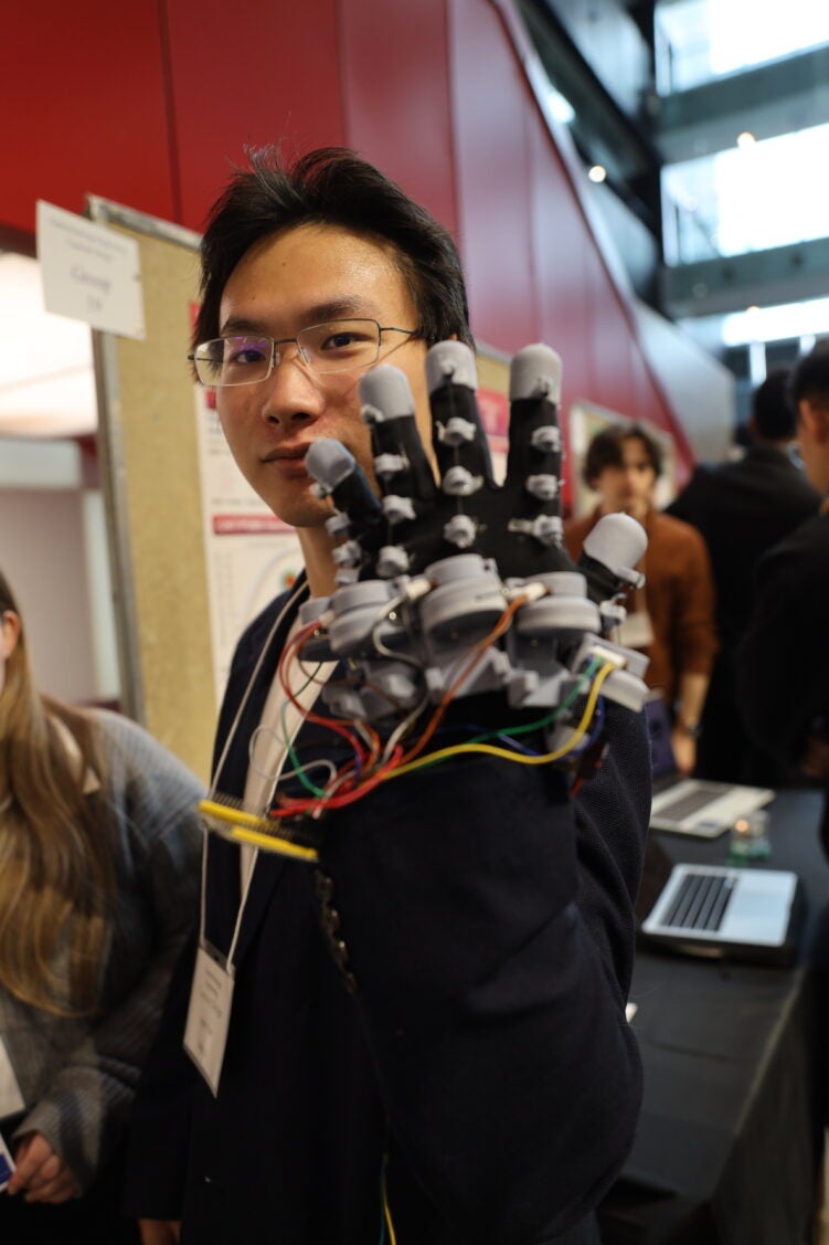 a man with glasses wearing a glove with wires