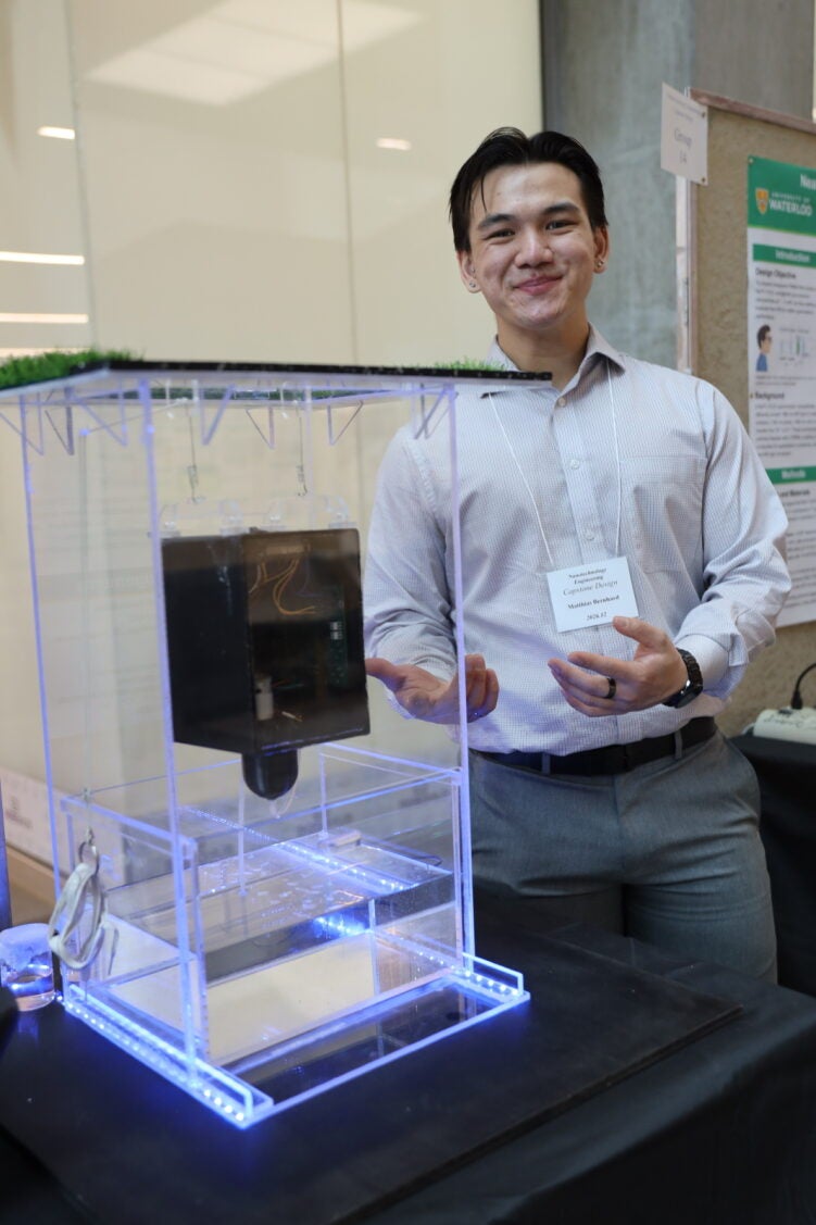 a man gesturing to a black object in a box
