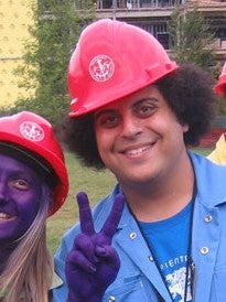 Mina Labib smiles and uses his purple hand to flash the peace sign during one of his Orientation Week events.