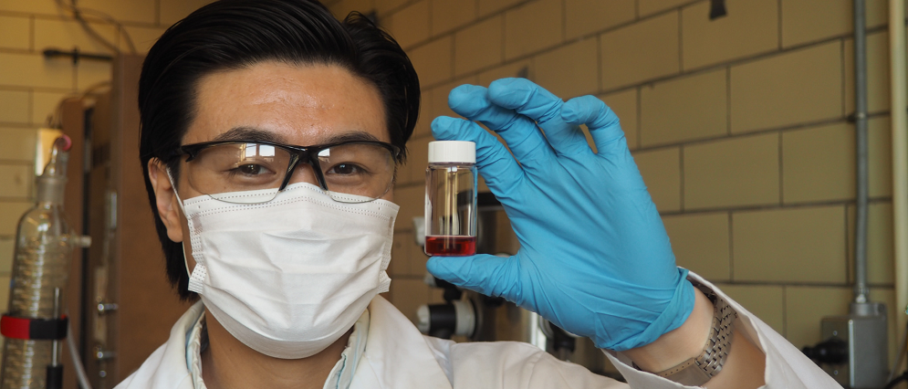 Paul Chen masked holding a vial with liquid