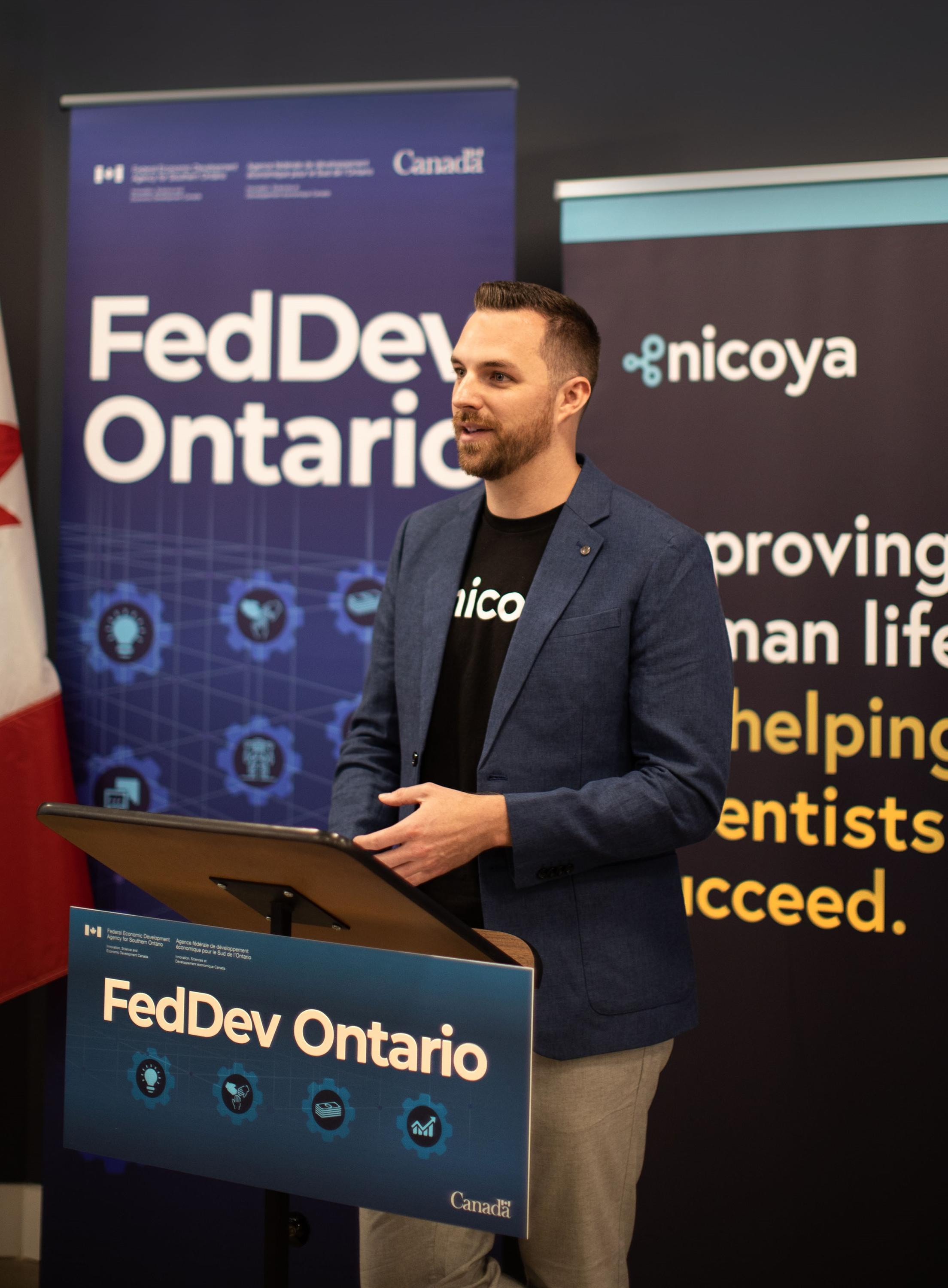 Ryan Denomme, speaking from behind a FedDev Ontario podium.