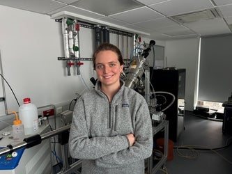 a woman wearing a grey hoodie smiling