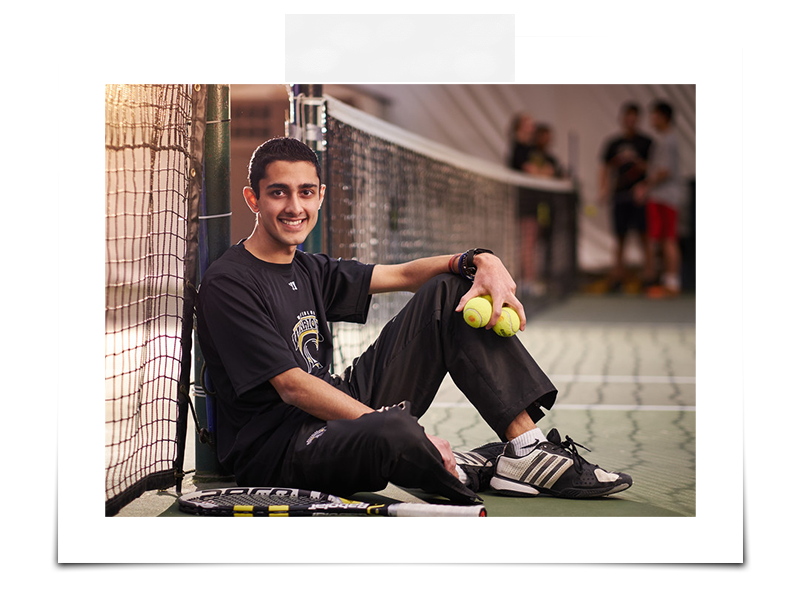 Student sitting on a tennis court