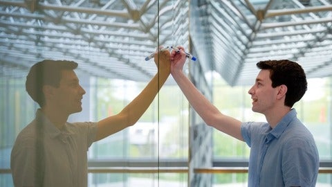 Cameron Dean writing on a whiteboard