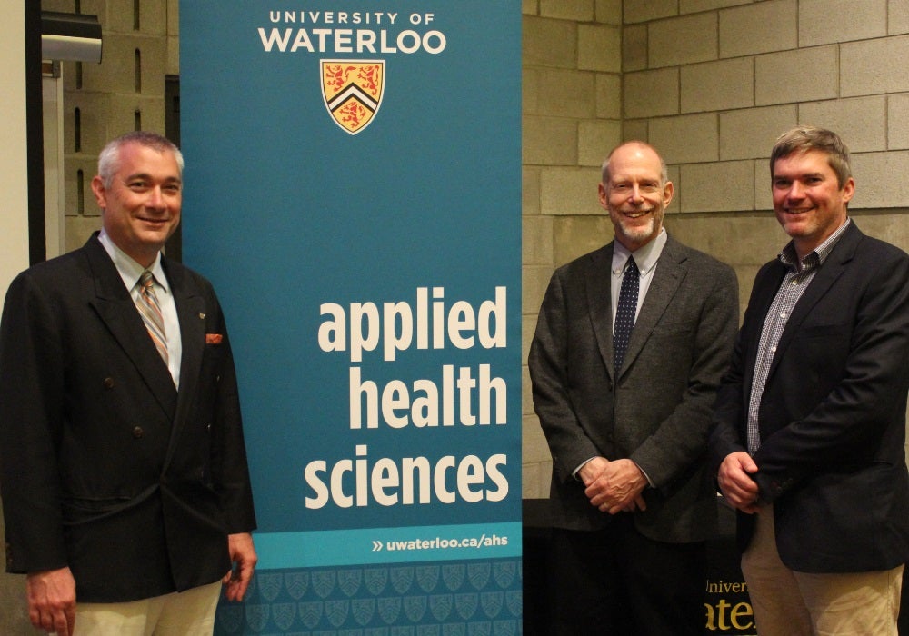 James Rush, Karl Pillemer and Steven Mock in front of the Applied Health Sciences banner.