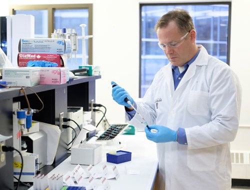 Professor Ken Stark taking a sample of blood in Waterloo laboratory