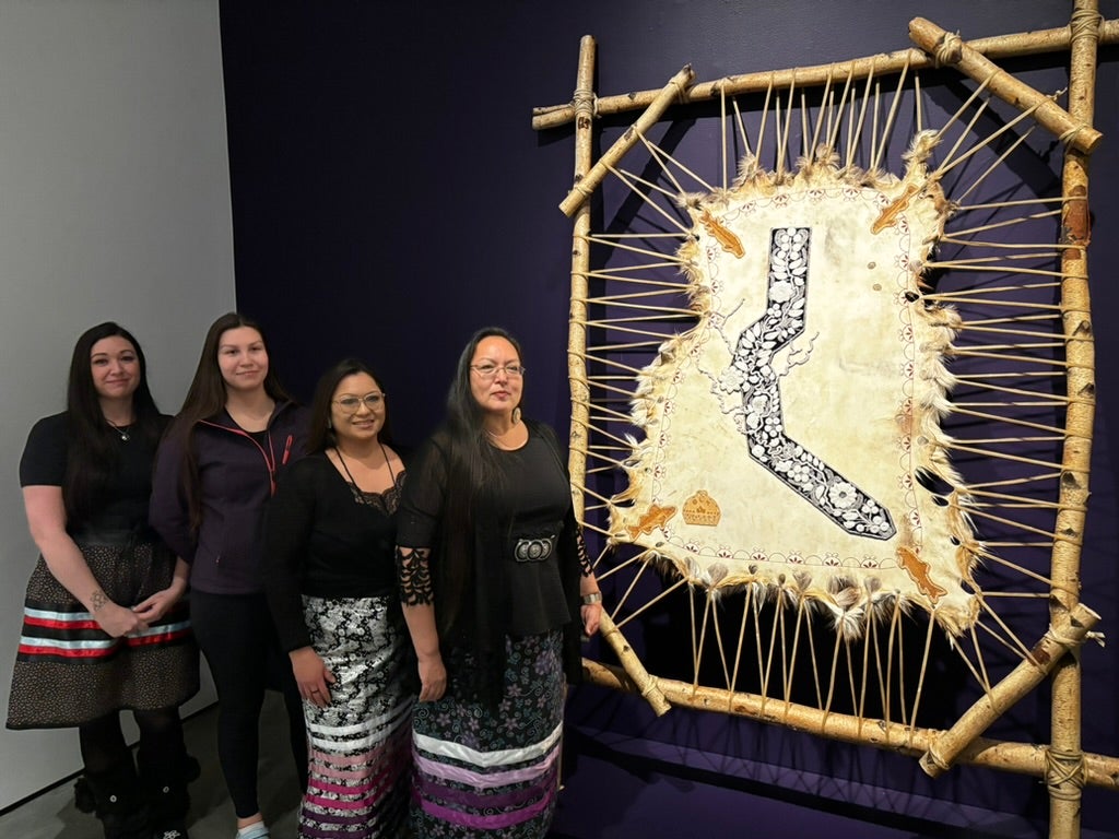 The four Indigenous artists who created Bead the Tract. Three are wearing traditional skirts featuring ribbons of colour