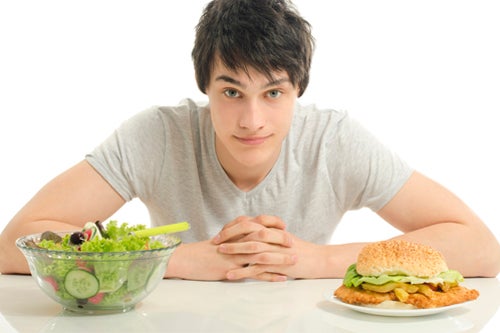 Man debates eating a salad or a burger and fries