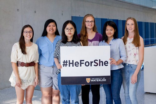 HeForShe scholarship recipients standing with #HeForShe sign