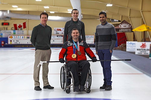 John McPhee (left to right), Conor Jansen and Borna Ghannadi of Waterloo Engineering pose with Team Canada skip Mark Ideson during testing of a new curling head.