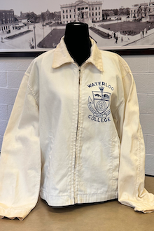 Front view of a white jacket with a logo and Waterloo College on it