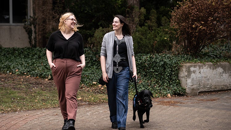 Emma Collington and Samantha Fowler walking with a dog