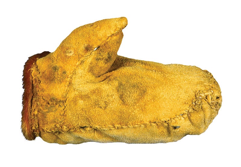 A yellow leather mitten hand stitched and lined with fur