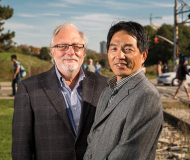 Liping Fu and Frank Saccomanno stand near a railway crossing