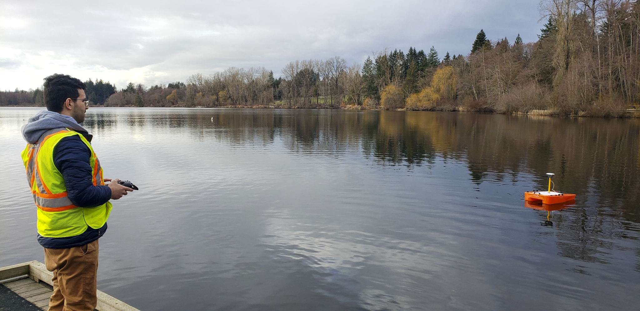 Hasti Shwan wearing a Geomount safety gear while operating a small boat on a lake in British Columbia