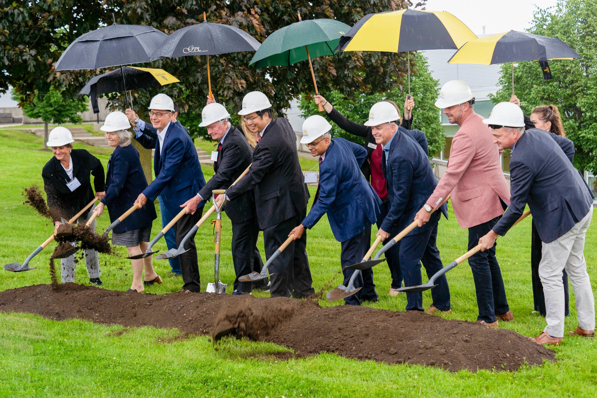 Dr. Stanley Woo, Dr. Vivek Goel, president and vice-chancellor of Waterloo, and other senior leaders participate in digging