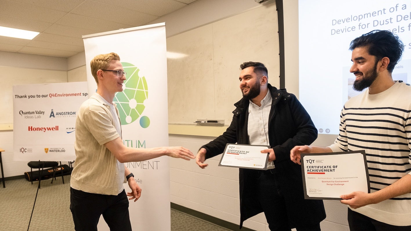 Amirhossein Boreiri and Miswar Syed accepting the Gold award from the Transformative Quantum Technology (TQT) team