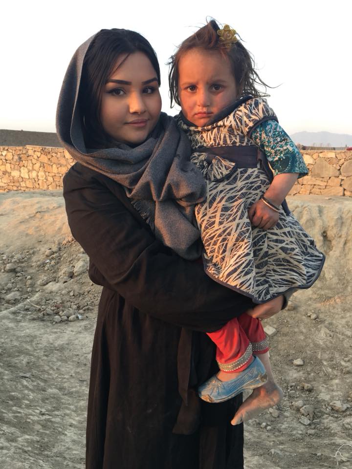 Sheha Akbari holding a child in Afghanistan