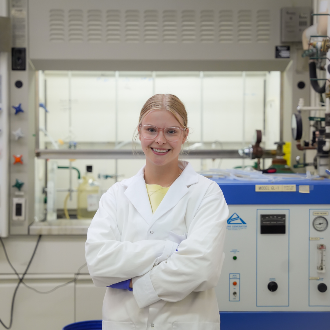 Alyssa wearing a white lab coating in a lab at the University of Waterloo.