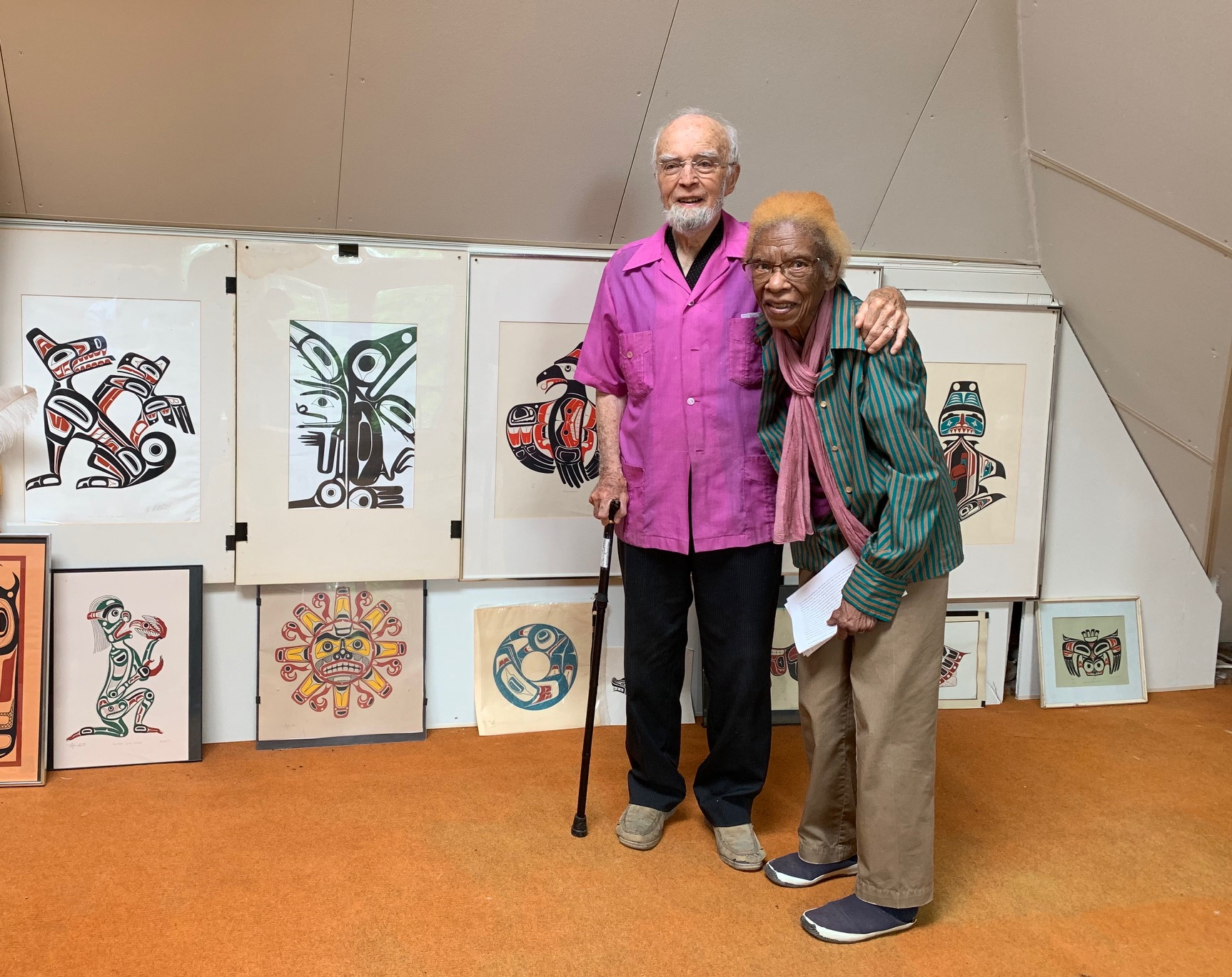 Yves and Cynthia Bled stand in front of a display of Indigenous art