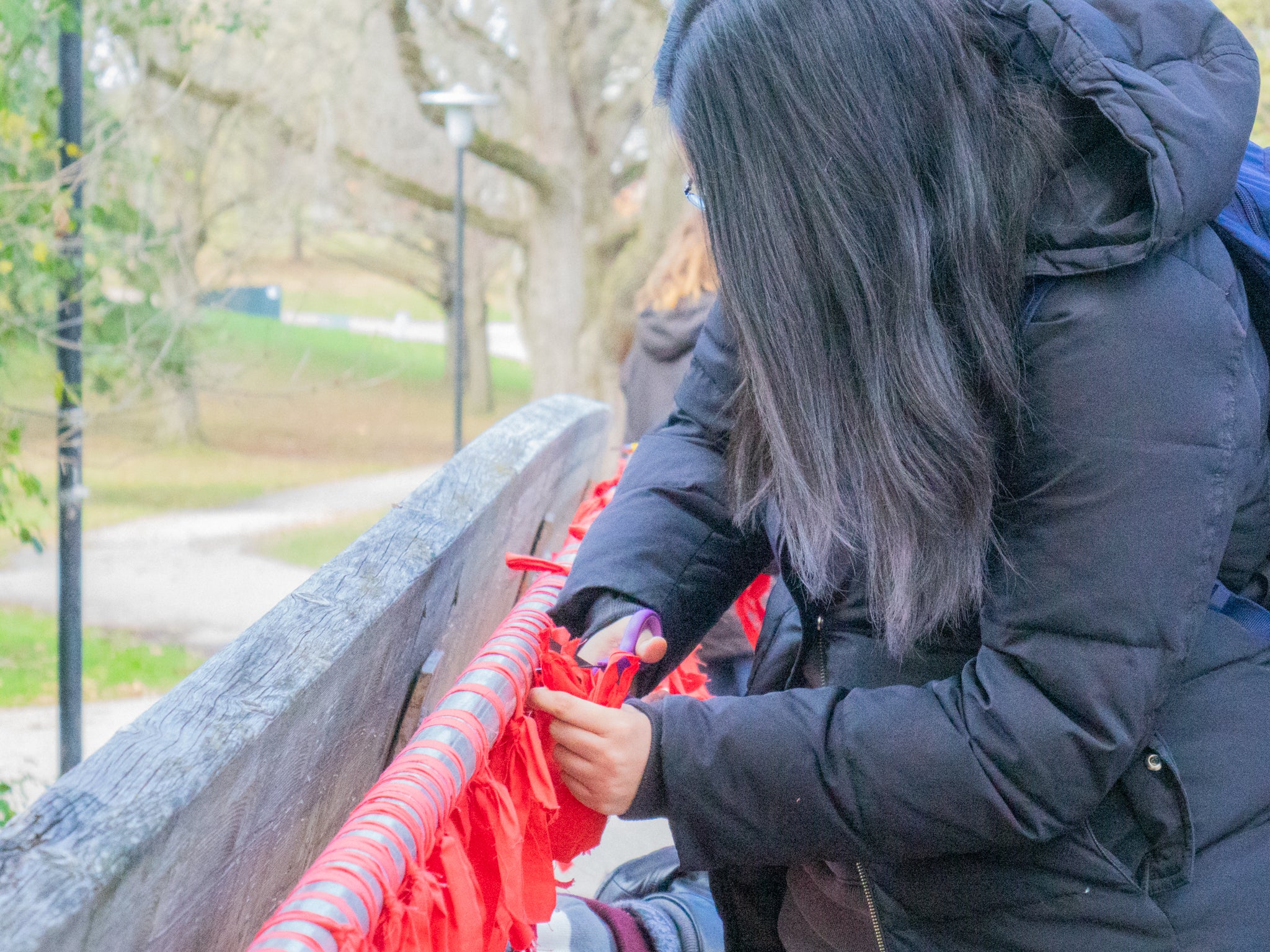 Participant cutting off red fabric ties from bridge