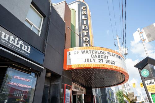 Outside the Eglinton Grand Theatre. Marquee letters read U of Waterloo features CAUGHT July 27 2023.