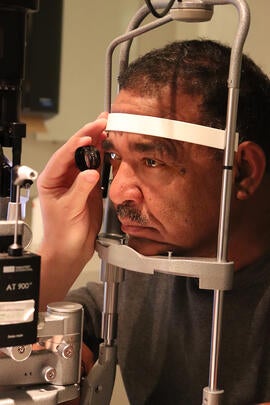 Optometrist performing an eye exam on a male patient
