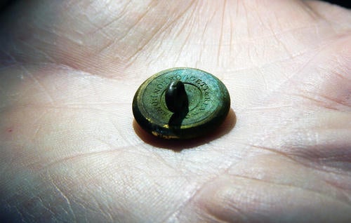 Close-up of maker's mark on back of gilt button. 