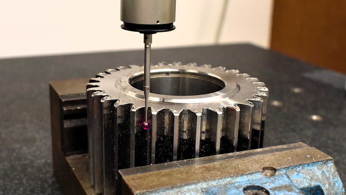 A close-up of the machine cutting a gear
