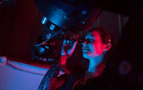 Emily Pass looking into the lens of a telescope at UW
