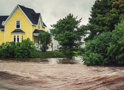 A fast moving river breaking its bank endangers homes