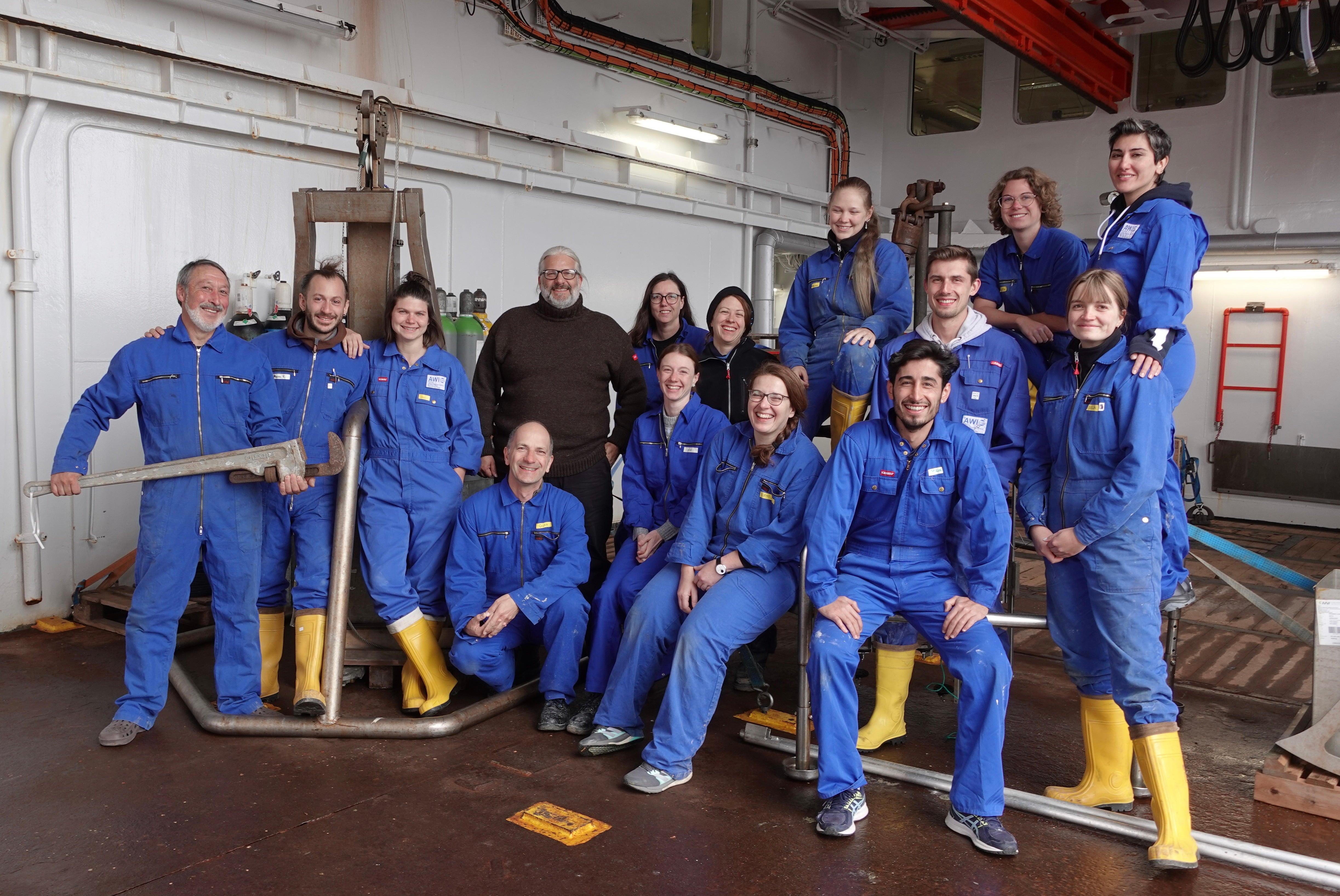 marine geology team in blue coveralls on ship