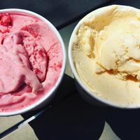 Two tubs of ice cream, pink on the left and yellow on the right