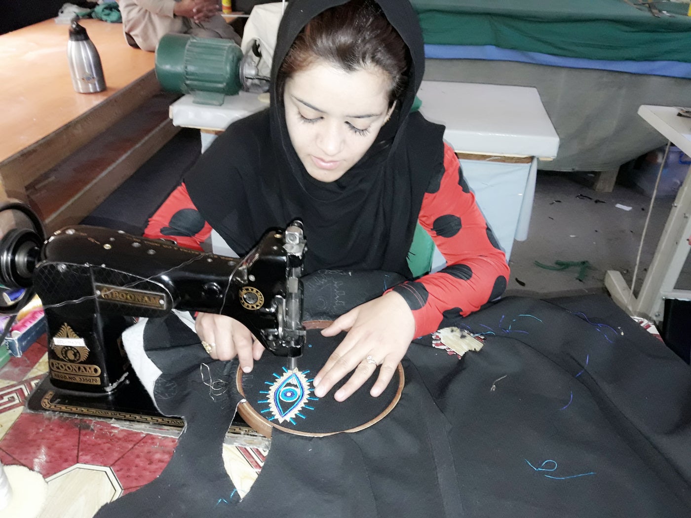 Afghan woman making embroidered patches