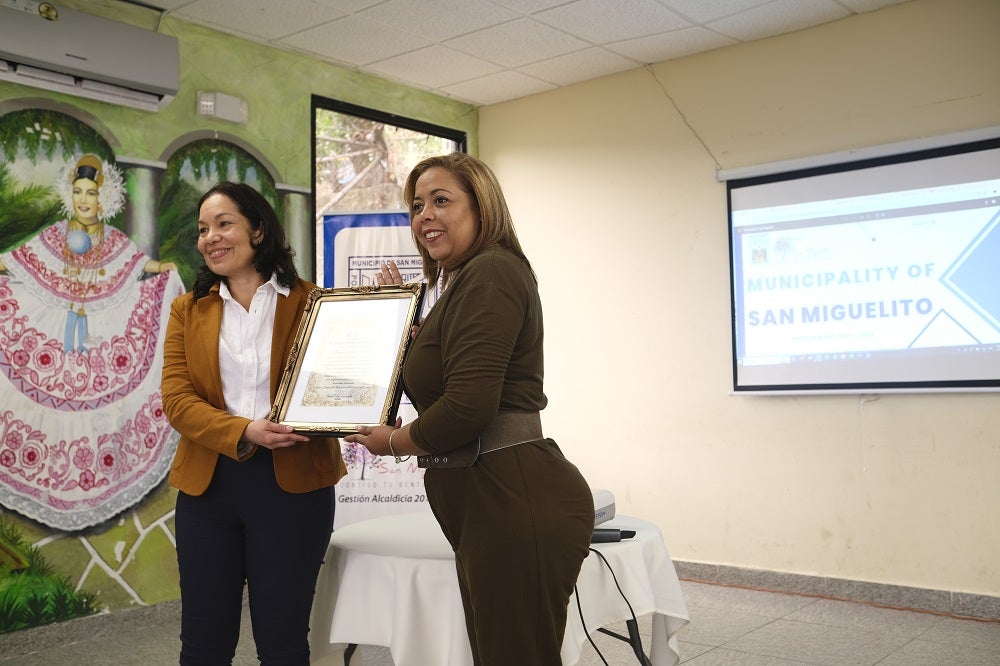 Ivonne holding a plaque at San Miguelito Municipality.