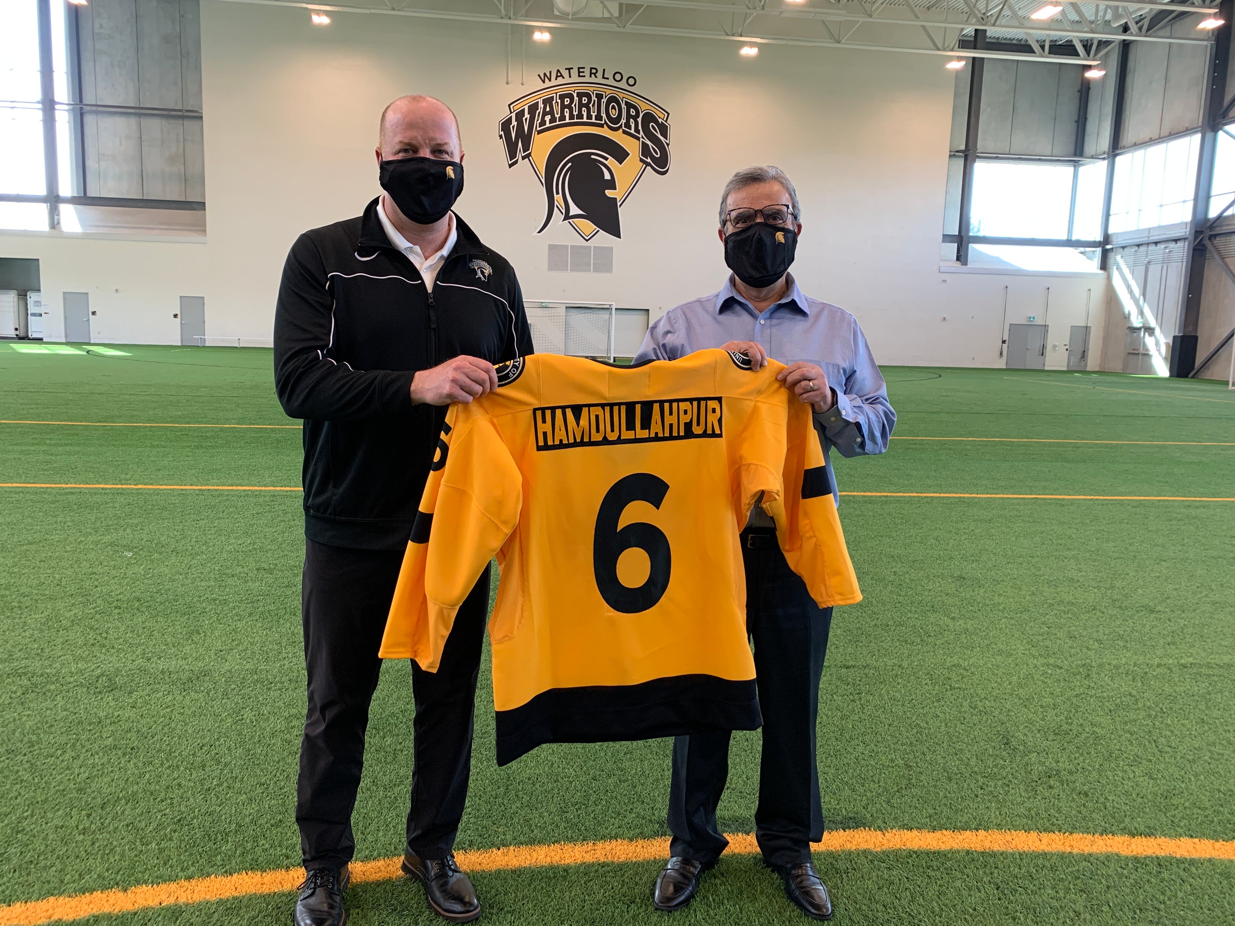 Roly Webster and Feridun Hamdullahpur holding a jersey that says Hamdullahpur