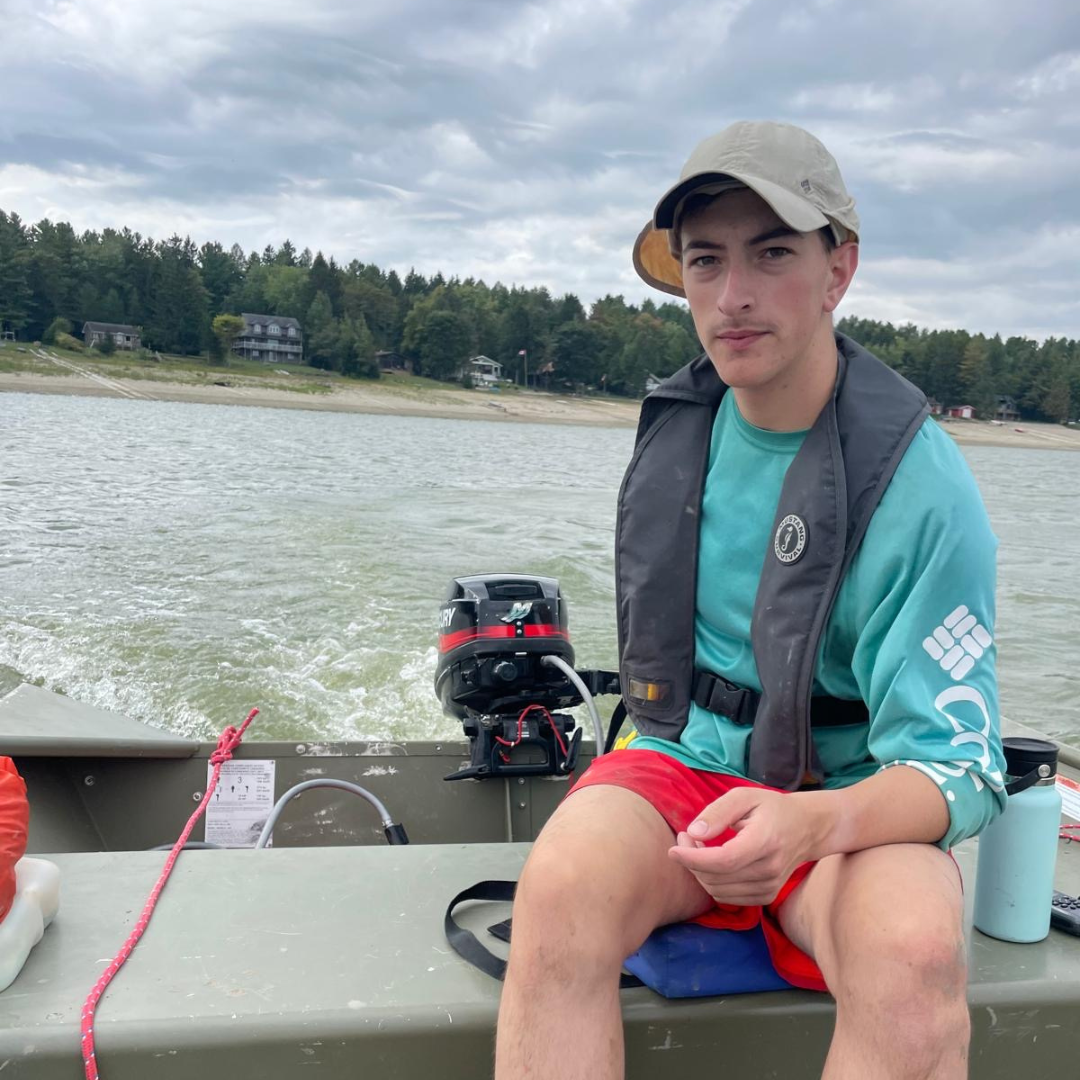 Joey driving a boat on a lake